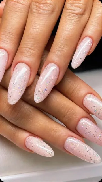 Sheer nude gel with holographic glitter on almond nails