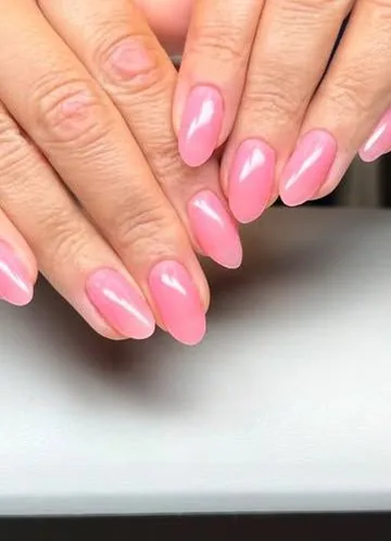 Warm pink gel manicure on almond nails, close up